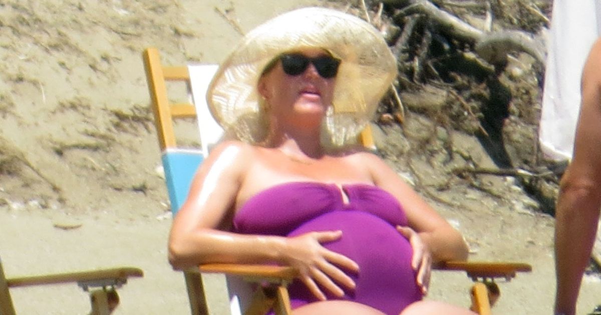 Pregnant Katy Perry ready to pop as she caresses her bump in purple swimsuit