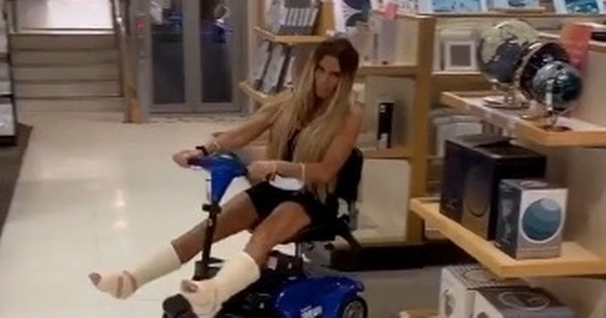 Katie Price speeds around with her legs spread as she jokes over broken feet