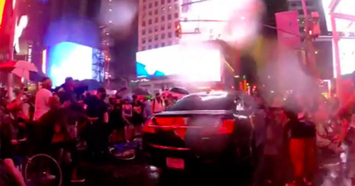 Car drives through Times Square protesters