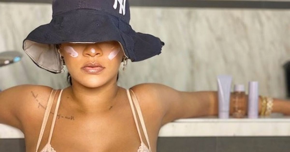 Rihanna shows off huge tattoo as she poses in a lace bra to plug beauty line