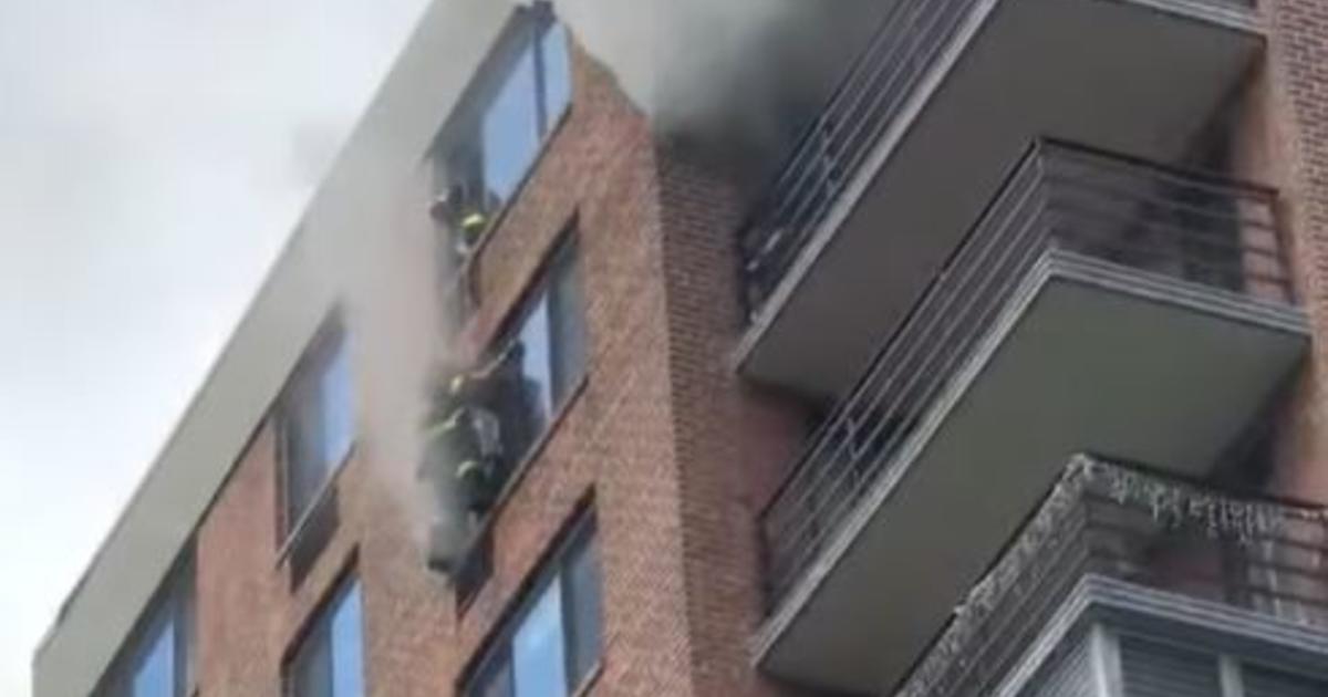 Firefighter rescues woman trapped in burning high-rise