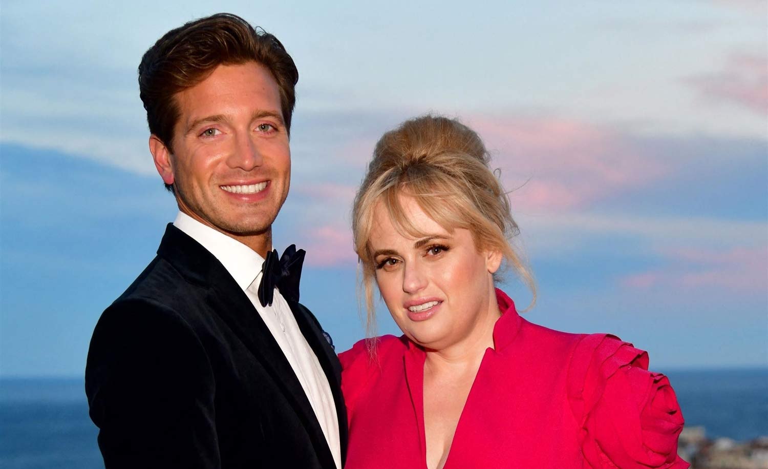 Rebel Wilson And Her BF Jacob Busch Pack The PDA In Cute Beach Video – Check Out Her Stunning Strapless Bathing Suit!