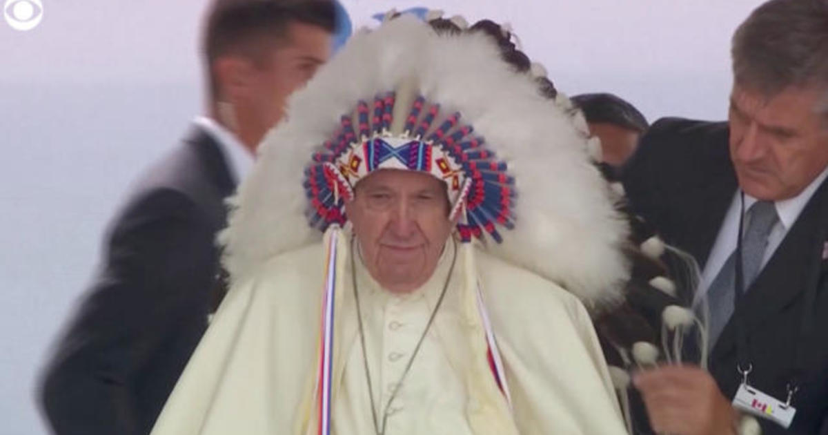 Indigenous leader places traditional headdress on Pope Francis